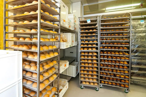 Commercial bakery racks loaded with bread on Beefy 4 Inch By 1.5 Inch Heavy Duty Oven Rack Casters Set Of 4 With 2800 Lbs Capacity