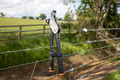 Torq Wire Tensioning Tool With Built In Gauge Tension Up To 880 Lbs on a barbed wire fence in a field
