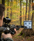 Aiming a crossbow at a 650 FPS Ravin Edition Crossbow Target For Archery Ultra High Speed Stop With Aramid Core Technology outdoors.