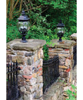Stone wall with mounted black lanterns in garden setting, illustrating use for Post Adapter For Surface Mounting Round Posts With Included Anchor Bolts And Set Screws Black Aluminum Flange Base No Brainer Install For Deck Railings Lighting Or Fence Posts.
