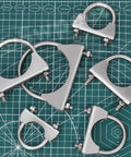 Multiple stainless 1.3 inch U-bolt clamps on a grid mat, part of Exhaust U Clamp Kit 2 Pieces 1.3 Inch Stainless Steel U-Bolt Clamps