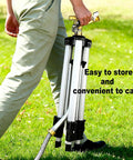 Person carrying a folded tripod lawn sprinkler, showcasing its portability. Tripod Lawn Sprinklers Pack Of 2 Heavy Duty 360 Degree Coverage For Yard And Garden Adjustable Height Tripod With Sprinkler Head Nozzle And Three Quarter NH Inlet Hose Connection Easy Setup And Wide Irrigation Reach.