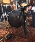 Badass Adjustable Snare Drum Rack And Practice Stand With Rock Solid Non Slip Base Plus Straight Up Portable Double Drumstick Shelf and Quick Hinge Height Adjustment For Pro Music Gear in a rehearsal setting.