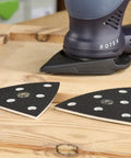 StickFix Hard Sanding Pad For DX 93 System, triangular pads with equal angle corners and convex edges on a wooden surface