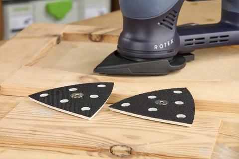 StickFix Hard Sanding Pad For DX 93 System, triangular pads with equal angle corners and convex edges on a wooden surface