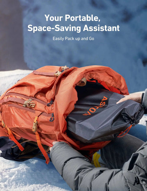 Orange backpack being packed with gear on a snowy background.