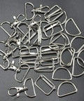 Top Shelf 60 Piece Bag Making Hardware Kit Featuring Swivel Snap Hooks D Rings Slide Buckles For Handbag Repairs Backpack Fasteners And Totally Sweet DIY Craft Builds In Polished Silver, assortment of silver snap hooks and D rings.
