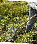 Heavy Duty Steel Garden Fork For Soil Loosening And Planting Area Prep in use on a farm with quick attach head for wooden handle.