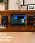 Desktop setup with Eris 3.5 Studio Monitors Pair for Near Field Mixing and HiFi Desktop Listening next to a laptop setup.