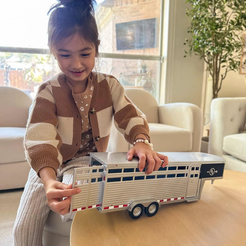 Child playing with Sundowner Horse Trailer With Gooseneck Hitch For Farm Toys And Toy Trucks Realistic Details 1:20 Scale