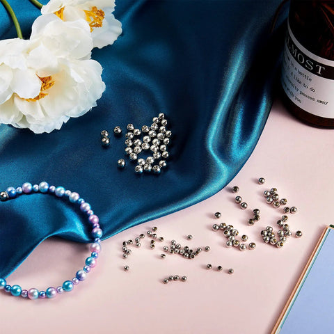 120 Pcs Memory Wire End Caps Set In Stainless Steel, silver beads for bracelets and jewelry making on blue fabric with flowers