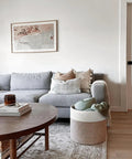 Cozy Cotton Rope Blanket Basket With Built In Handles beside a gray sofa, ideal for living room storage, 15.8 x 15.8 x 13.8 inches.