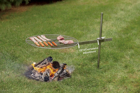 Go To Campfire Grill For Outdoors Lovers, Premium Stainless Steel Portable Cooking Gear For Camping And Backyard Grilling, 24 Inch Cooking Surface shown installed over fire with adjustable stake