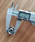 Hydraulic hose fitting adapter, metal with threaded bore, measured by digital caliper (close-up view).