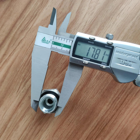Hydraulic hose fitting adapter, metal with threaded bore, measured by digital caliper (close-up view).