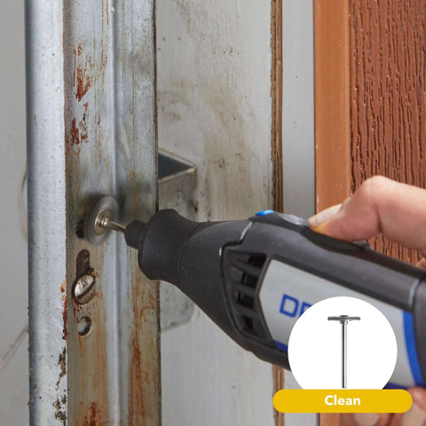Dremel rotary tool with grinding bit used on a rusted metal door frame