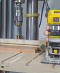Woodworking bench with a handheld router and Matchfit Dovetail Clamps Four Pack Exclusive Bundle with Dovetail Router Bit in use