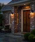 Outdoor scene with Newbury 14 Inch Outdoor Wall Lantern in Mystic Black With Clear Beveled Glass, illuminating a brick porch.