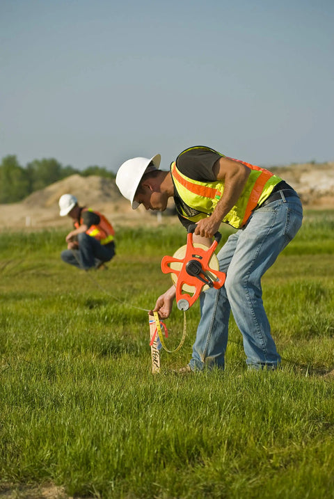 Worker using Hi Viz Orange Fiberglass Tape Measure Half Inch By One Hundred Meters Dual Sided SAE And Metric Tape With Open Four Arm Frame