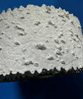Close-up of Self-Adhesive Pre-Textured Popcorn Ceiling Patch Roll, Paint Ready, 2 In By 5 Ft, Heavy Popcorn Finish on blue background.