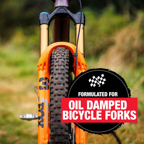 Front view of oil-damped bicycle fork featuring the 10Wt Suspension Shock Oil For All Bicycle Forks And Seals, 16oz Bottle.