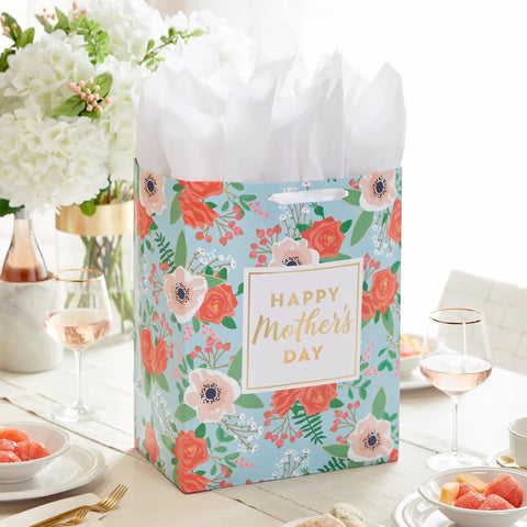 Extra Large Mothers Day Gift Bag With Tissue Paper In Bright Blue Featuring Red Roses And Green Foliage on dining table