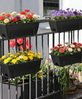 Black window boxes with colorful flowers on a balcony railing, part of the Level Up Your Porch Decor With This Ace Two Tier Railing Planter Box Set.