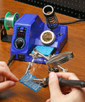 Hands using the Ready To Roll Soldering Station Kit With 130W Max Power And 926LED V3 on a circuit board with tools and accessories.