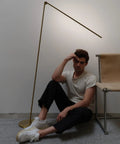 Libra LED Floor Lamp With Adjustable Pivot Arm And Built In Dimmer beside modern chair, brass design for reading