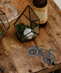 Bike Shaped Multitool Keychain For Cyclists Stainless Steel Portable Pocket Tool on rustic wooden table