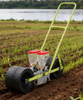 Manual 2 Row Corn Seeder Hand Push Precision Planter With Adjustable Seed Dispenser in farm field near water