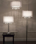 Moiselle Swanky Modern Table Lamp With Chrome Finish, Double Drum Shade In Sheer Off White, on dark wood table, room setting