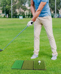 Man practicing with 3-In-1 Golf Practice Mat With Realistic Turf Surfaces For Hitting Swing And Putting Training Indoor Outdoor Practice Aid Wind Shear Upgrade Includes 35mm Rough Turf 16mm Green Turf And 10mm Fairway Turf on grass