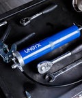 Heavy Duty Pistol Grip Grease Gun Kit 14oz Mini Grease Gun With 6000 PSI Leakproof Seal And Flexible 12 Inch Hose laying on a workbench