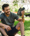 Person holding Camouflage Insulated Water Bottle 1L With Strap And Thermal Lining Rugged Aluminum Hydration Flask