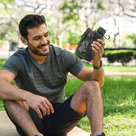 Person holding Camouflage Insulated Water Bottle 1L With Strap And Thermal Lining Rugged Aluminum Hydration Flask