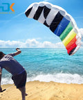Person flying Rainbow Parafoil Kite 55 Inch Pro Stunt Soft Foil Design With 1.4 M Wing Span on beach with ocean background