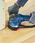 Person using six inch hard hook and loop sanding pad with multi hole dust extraction, fiberglass reinforced backing plate.