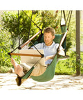 Blue Hanging Hammock Chair With Wooden Dowels, 350 Lb Capacity, Includes Carrying Case, shown on patio with laptop user