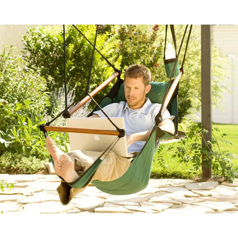 Blue Hanging Hammock Chair With Wooden Dowels, 350 Lb Capacity, Includes Carrying Case, shown on patio with laptop user