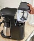 Person installing Advanced Water Filter Cartridges For 12-Cup Programmable Coffee Makers, 2 Pack White, 60-Day Supply