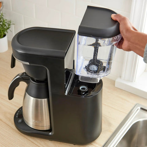 Person installing Advanced Water Filter Cartridges For 12-Cup Programmable Coffee Makers, 2 Pack White, 60-Day Supply