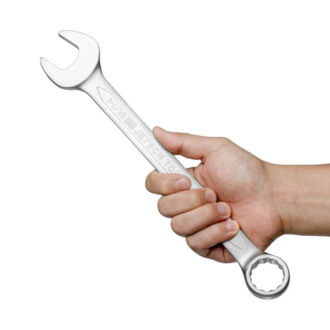A hand holding Heavy Duty One And One Sixteenth Inch 12 Point Combination Wrench With No Slip Grip For High Torque In Industrial Chrome Vanadium Steel Spanner 15 Degree Offset Sand Blasted Finish Heat Treated Forged Tool.