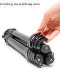 Hand holding folded Carbon Fiber Travel Tripod With Pro Level Stability, Fast Setup And Takedown, Ergonomic Ball Head, Ultra Compact And Portable.