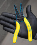 Reflex Super NM Cable Stripper For 12/2 And 14/2 Solid NM Wire in gloved hand, plier nose, yellow textured grip, dual stripper heads