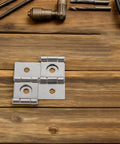 Retro Square Iron Cabinet Hinges And Lifting Brackets Set for doors on wooden surface with tools. Solid metal build.