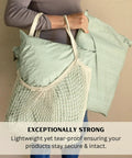 Person holding 14x19 Sage Green Boho mailers in net bag showcasing Extra Large 14x19 Inch Poly Mailers Pack Of 50 Self Sealing Waterproof And Tear Proof Envelopes For Clothing Shipping With Sage Green Boho Design Great For Small Biz Packaging And Durable Protective Mailers