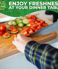 Slicing fresh tomatoes and cucumbers on a wooden cutting board in a kitchen setting