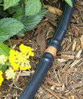 Half Inch Drip Irrigation Coupling Fittings 12 Pack Barbed Connectors in use on black tubing with yellow flowers nearby