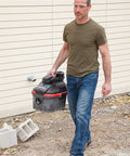 Man carrying 4-Gallon Portable Wet And Dry Vacuum Cleaner With A 5.0 Peak HP Motor, red finish, showing lightweight design.